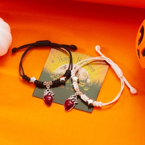 Halloween Armbänder mit roten blutenden Herzanhängern und Sternperlen auf festlichem Dekor