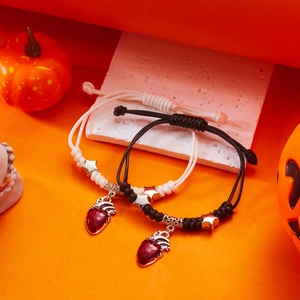 Detail der gewebten Halloween-Armbänder mit realistischen Herz- und Sternanhängern