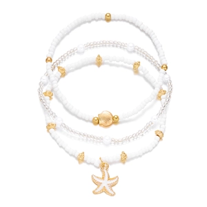 Macro view of four-piece beaded bracelet set featuring golden shell and starfish charms