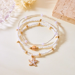 Detail view of Bohemian seed bead bracelets with starfish and seashell charms set
