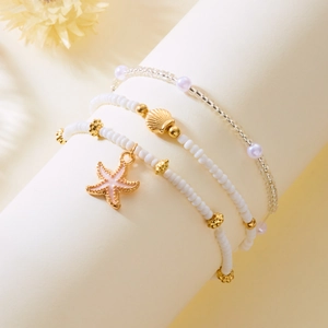 Detail of bohemian ocean bracelet set with starfish, seashell charms and white beads