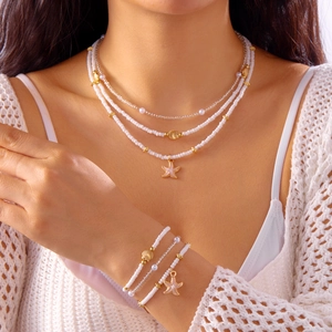 Bohemian layered necklace and bracelet set with white beads, gold starfish and sea shells