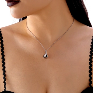 Detail der silbernen Halskette mit blutendem Herzanhänger am Model im Gothic-Stil