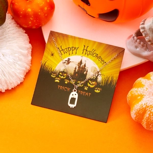 Geister-Halskette mit Gruselgesicht auf Halloween-Displaykarte mit Kürbissen und Schloss