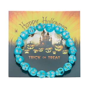 Detalle de pulsera de calaveras azules en resina sobre una tarjeta temática de Halloween