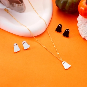 Halloween-Schmuckset mit goldener Kette und Geisterohrringen auf orangefarbenem Hintergrund
