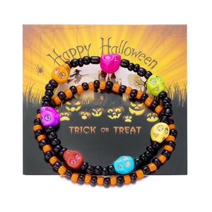 Detalle de pulseras de Halloween con calaveras de resina de colores en tarjeta festiva