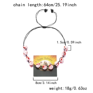 Halloween necklace detail with bloody white beads and dimensions on branded card