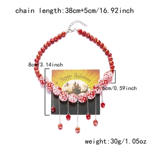 Detailed view of Halloween beaded necklace with red ghost patterns and metal tassels