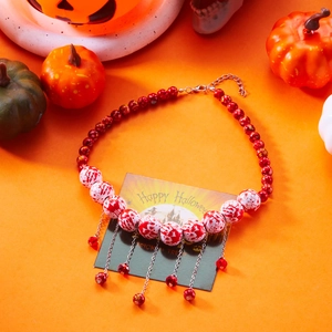 Detail of Halloween necklace with red beads, bloody patterns, and silver fringe chains