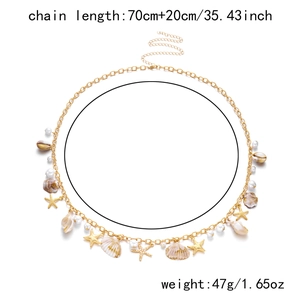 Detail of bohemian gold waist chain with pearls, shells and starfish charms
