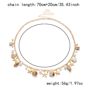 Detail of bohemian gold waist chain with seashell, starfish, and pearl charms