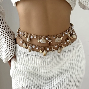 Detail of bohemian gold waist chain with sea shells, pearls and starfish charms