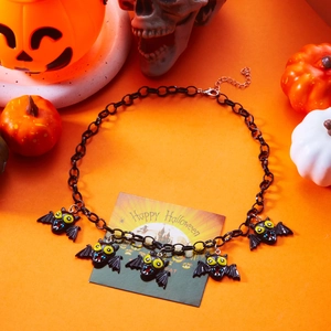 Close-up of black chain necklace with spooky yellow-eyed bat pendants for Halloween party