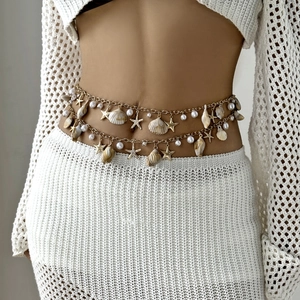 Detail of bohemian gold waist chain with sea shells, starfish and pearls for summer beachwear
