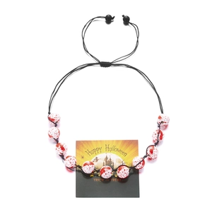 Detailed view of Halloween necklace with blood-splattered white beads and ghost theme card