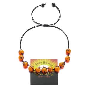 Detail of Halloween bracelet with orange spider beads on festive trick or treat card