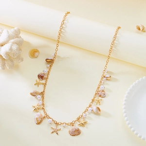 Detail of bohemian gold waist chain with sea shells, pearls and starfish charms