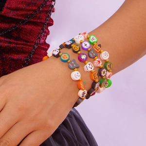 Detalle de pulseras de arcilla polimérica con dijes de calabaza y fantasma de Halloween