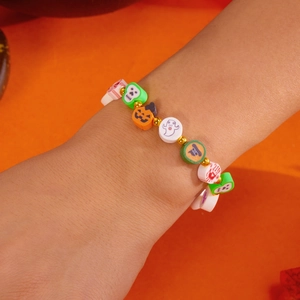 Primer plano de la pulsera de Halloween con dijes de arcilla de calabaza, calavera y fantasma