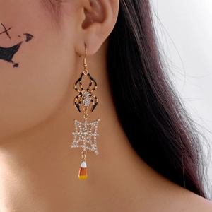 Detail of Halloween drop earring featuring a spider web and candy corn on model