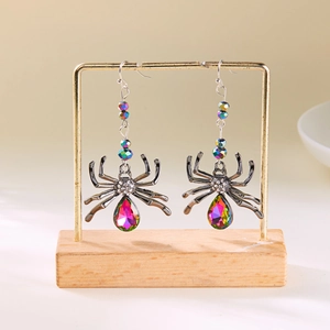 Gros plan de boucles d'oreilles araignée gothiques avec cristaux irisés et pavé de diamants