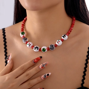 Detalle de collar de Halloween con cuentas rojas y dijes de murciélago y ojo real
