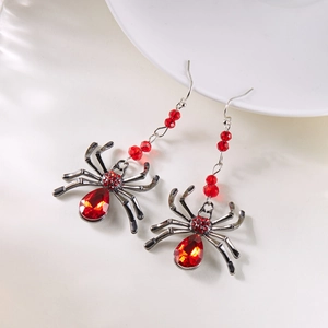 Détail de boucles d'oreilles araignée gothiques avec pierres rouges et métal noir poli