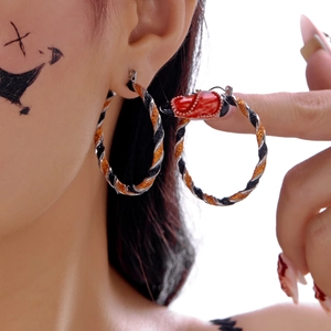 Detail of orange glitter and black enamel spiral hoop earrings for Halloween style