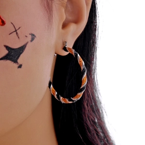 Detail of twisted hoop earrings with silver black and orange glitter for Halloween