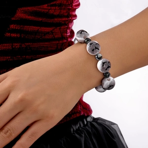 Primer plano de pulsera de Halloween con silueta de murciélago sobre cuentas de resina