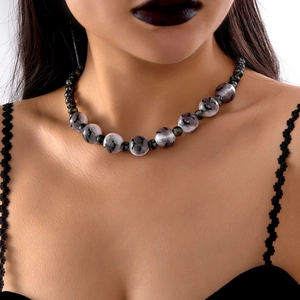 Primer plano de collar gótico con cuentas de mármol gris y estampados de murciélagos