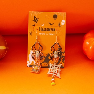 Detail van Halloween asymmetrische pompoen oorbellen met spinnenweb en trick or treat