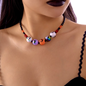 Detalle de collar de Halloween con cuentas y dijes de calabaza y fantasma en modelo