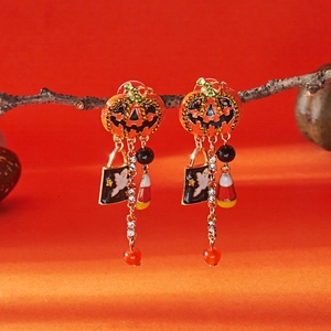 Detail of Halloween pumpkin drop earrings with sparkling rhinestones and long tassels