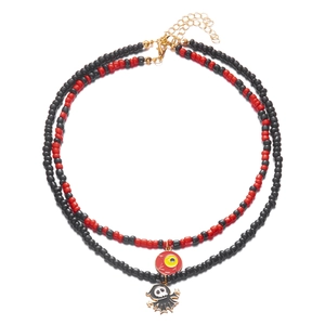 Detail van rood-zwarte Halloween-kralenketting met hangers van een oogbol en spook