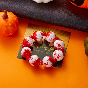 Detalle de la pulsera de Halloween con huellas de manos ensangrentadas y embalaje festivo