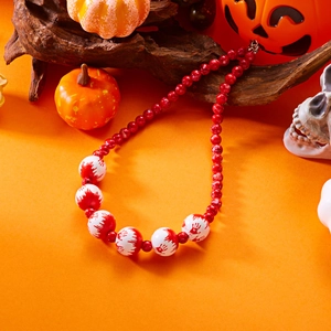 Collar de Halloween con cuentas blancas y rojas de huellas de sangre sobre fondo naranja