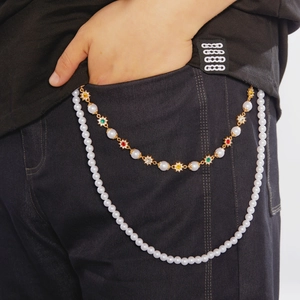 Détail de la chaîne de taille double couche avec perles blanches et fleurs en strass colorés