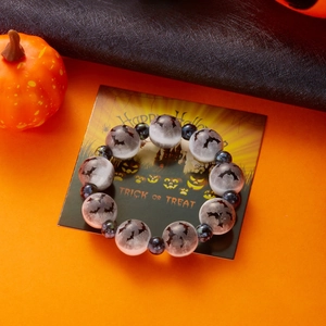 Detalle de pulsera de Halloween con motivos de murciélagos negros y cuentas azul oscuro