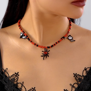 Close-up of Halloween beaded necklace featuring spider, bat, and grim reaper pendants