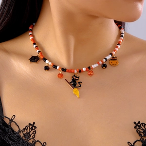 Close-up of Halloween beaded necklace with pumpkin, spider web, and black cat charms