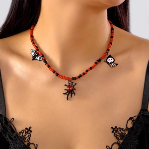 Detail view of Halloween beaded necklace featuring bat, spider web, and reaper charms