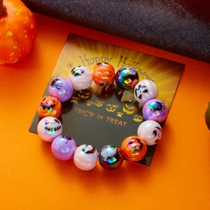 Primer plano de pulsera de Halloween con cuentas, motivos de calabaza y calaveras