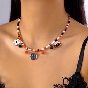 Detail of Halloween beaded necklace with ghost and spider pendants on a model