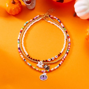 Three-piece Halloween beaded necklaces with pumpkin, ghost, and BOO pendants on orange background