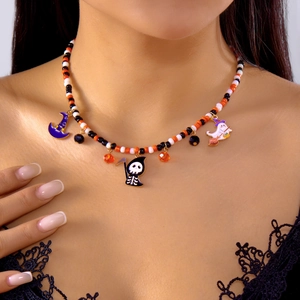 Close-up of handmade Halloween beaded necklace with pumpkin and ghost enamel pendants