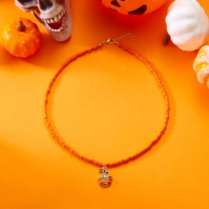 Detail of orange beaded necklace with a wizard hat pumpkin charm for Halloween