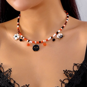 Detail of Halloween beaded necklace with pumpkin colors, cat and spider web charms