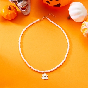 Close-up of Halloween beaded necklace with ghost charm and gold-plated clasp on orange background